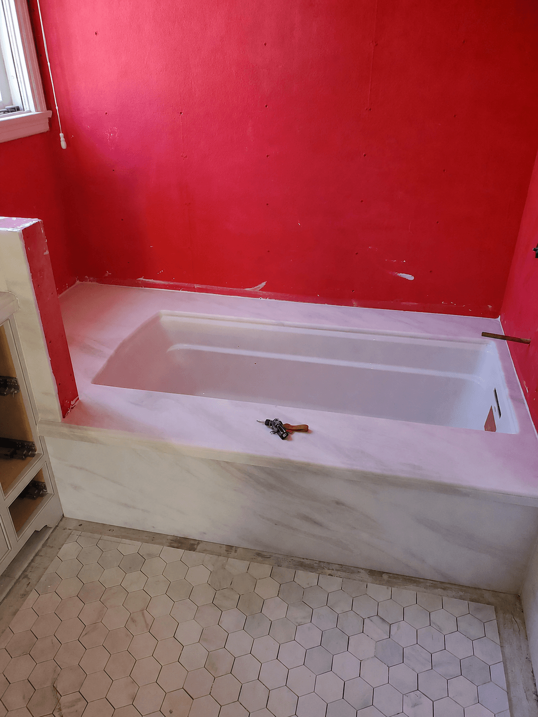 Marble tub deck with hexagonal floor tile in a San Marino bathroom